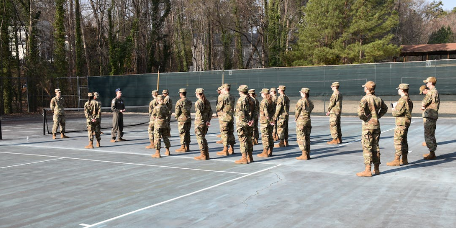 JROTC students standing on a tennis court facing instructors