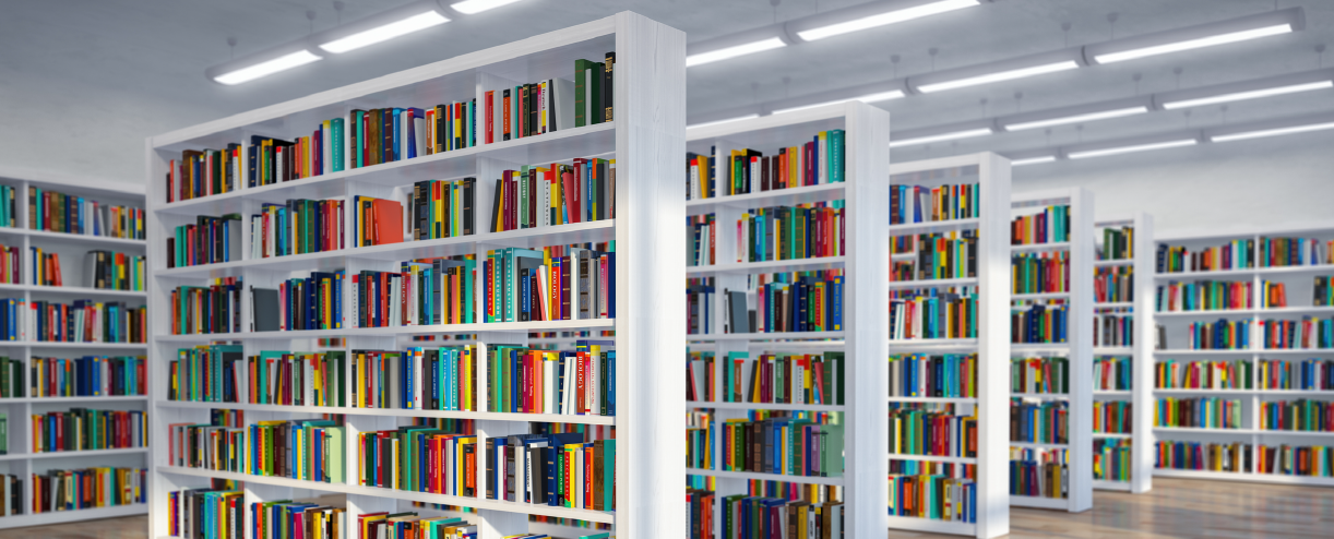 Photo of a library with rows of white bookshelves and colorful books