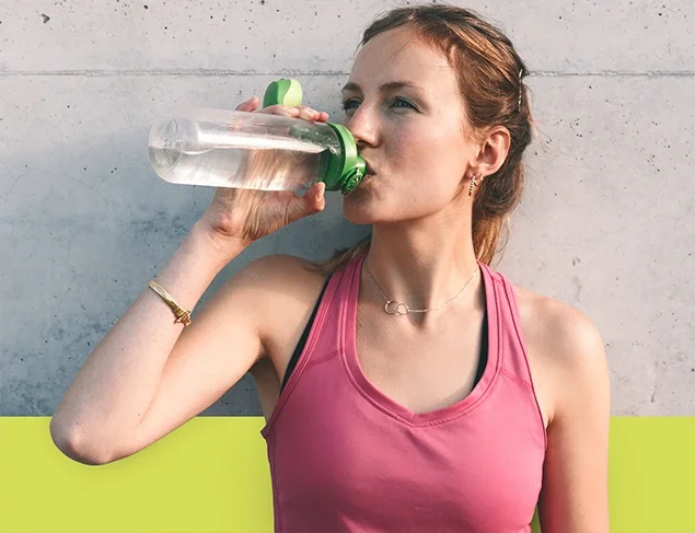 woman wearing a pink shirt drinking water