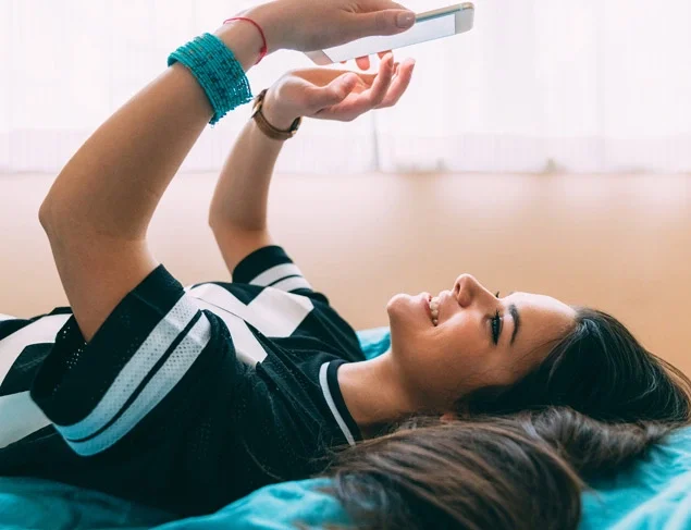 Young woman staying home in self-isolation enjoying to talk with friends on video call