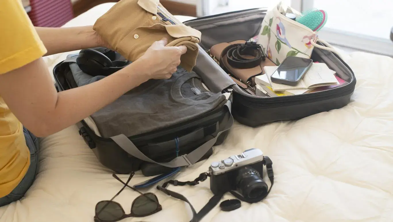 Women packing her suitcase on bed
