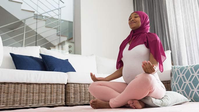  Pregnant woman practicing yoga at home