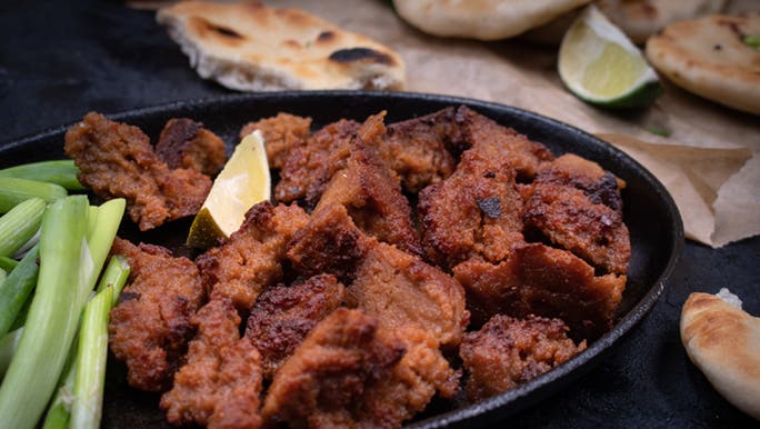 Fried seitan on a plate which is a plant-based ‘meat’.