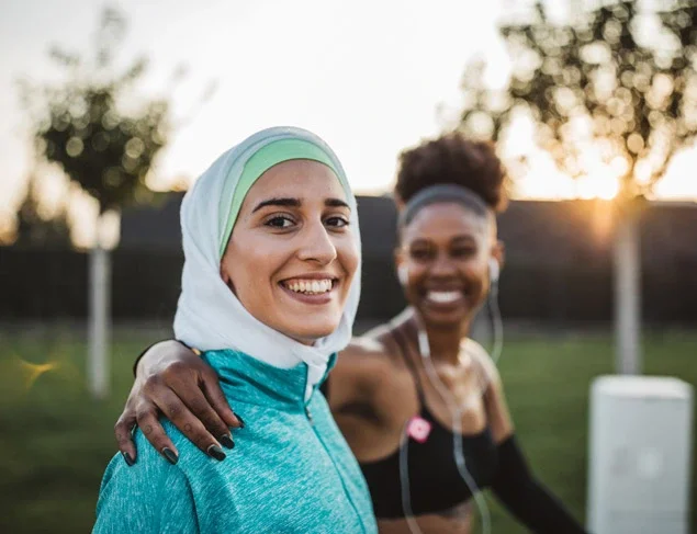 Happy young woman about to exercise with a friend