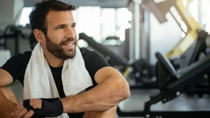 Man sitting and resting in the gym after a workout