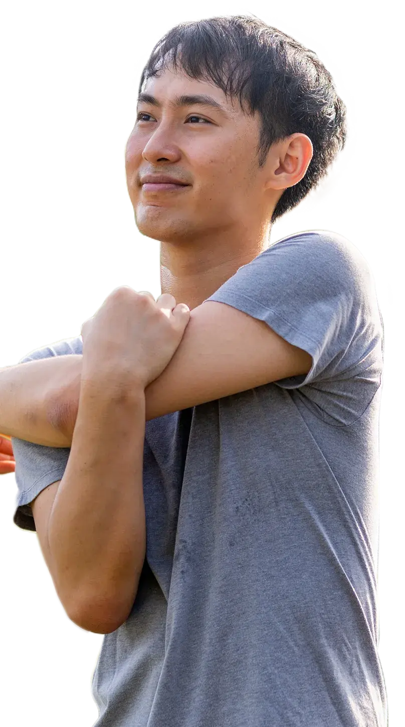 Waist up shot of a man stretching his shoulders and smiling.