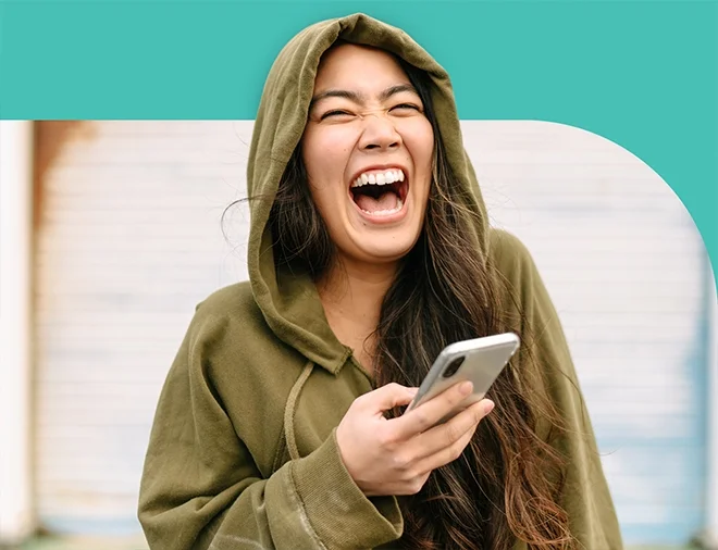 woman laughing holding phone