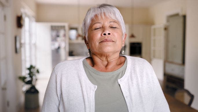 A senior woman with her eyes closed doing breathwork for beginners