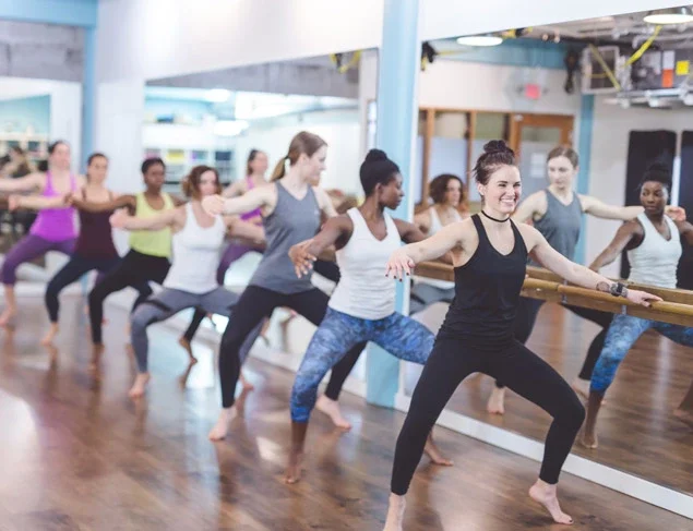 Group of women doing a barre class at the gym