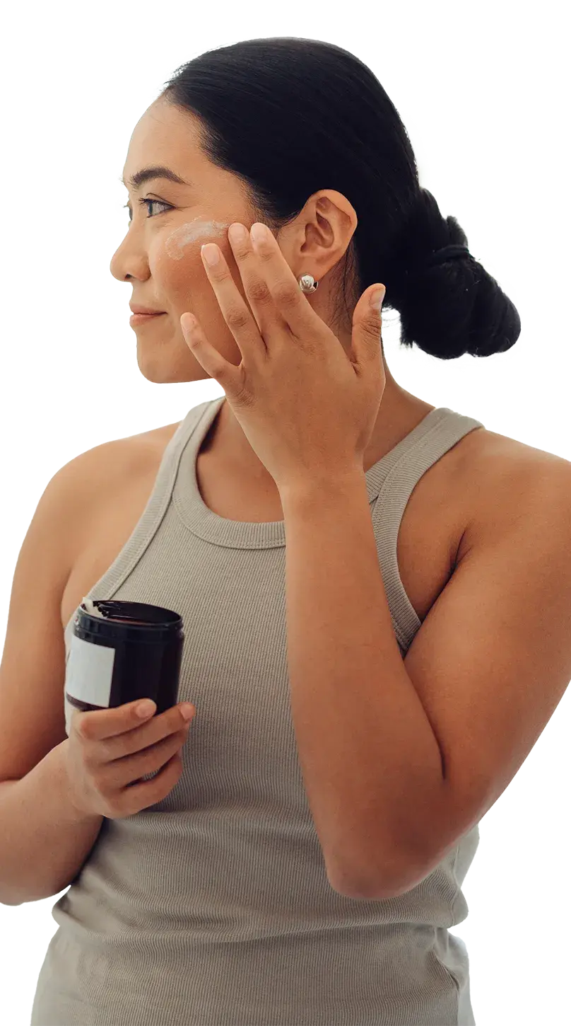 Midshot of a woman applying a skin cream to her face