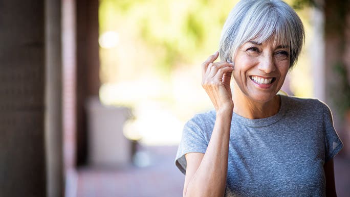 Happy woman with grey hair getting ready for a workout