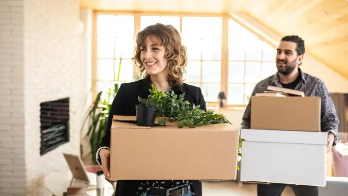 Couple carrying cardboard boxes after cleaning up and decluttering