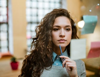 Concentrated woman making plan on sticky notes.