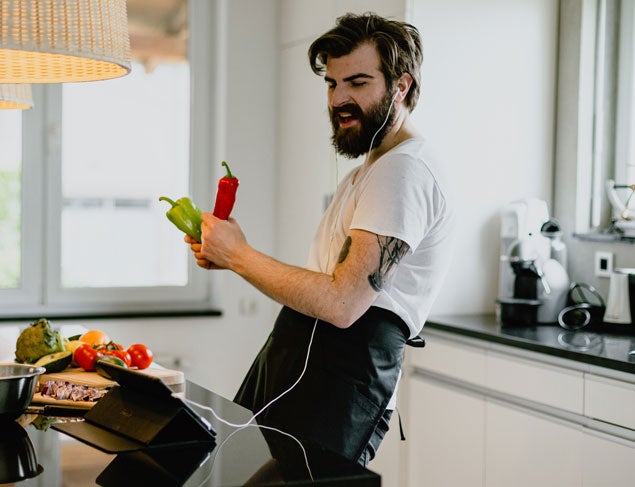 Young man cooking with vegetables