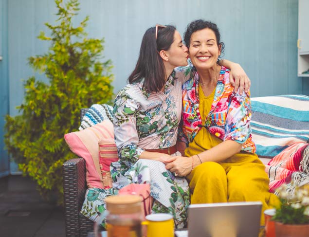 Happy mother and daughter together sitting outside enjoying each others company