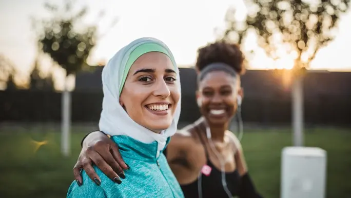 Happy young woman about to exercise with a friend