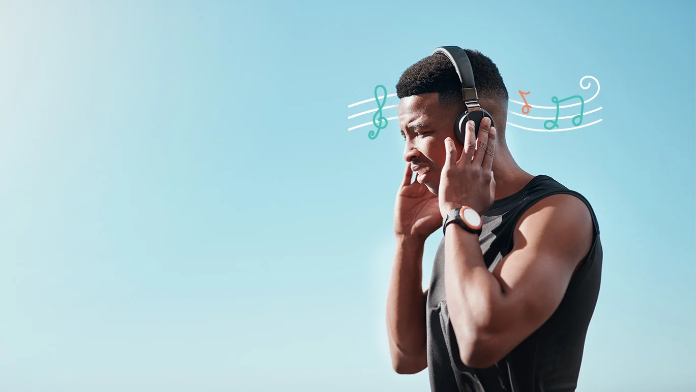Young man in a muscle top listening to music on wireless headphones