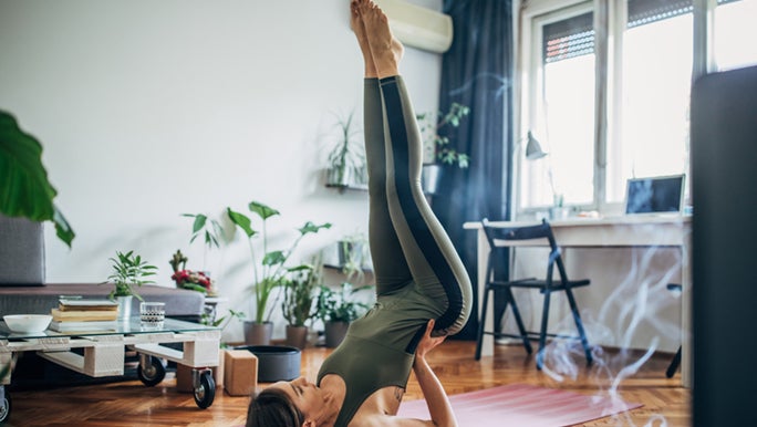 Woman practices Yoga in her home.