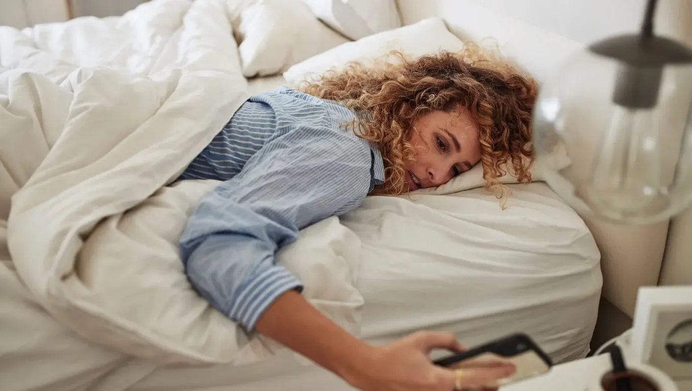 Women pressing snooze button on mobile phone