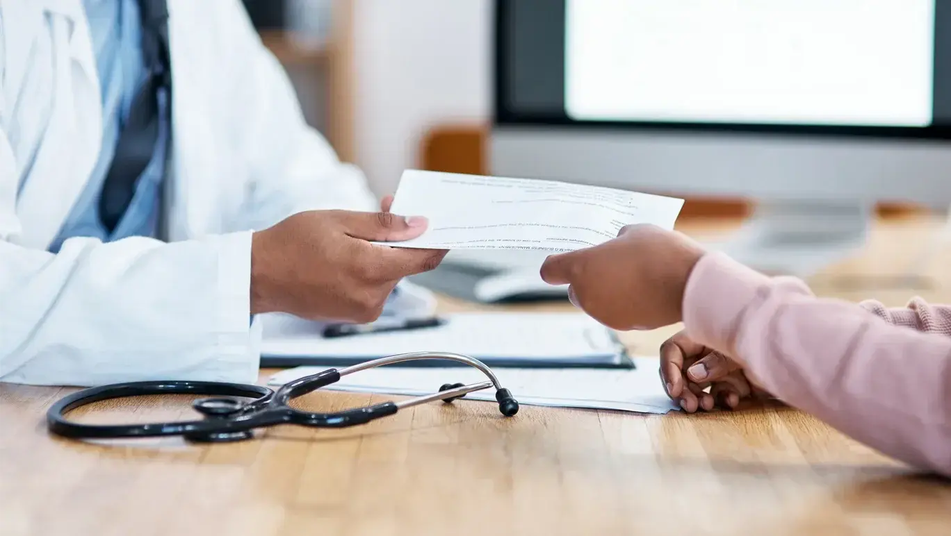 Doctor handing patient a medical certificate