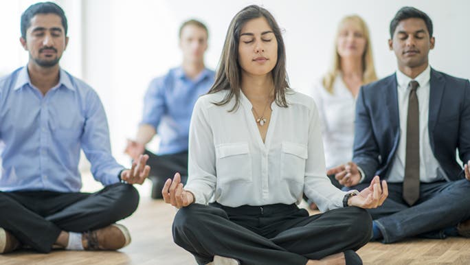 After having good food for their mood, a group of professionals meditate together.