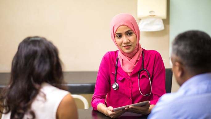 A man and woman are visiting their GP, discussing the health of their reproductive health, as it’s different for a man and woman.