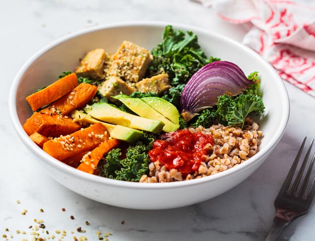 Vegan buddha bowl with tofu, buckwheat, kale, carrots, red onion and avocado