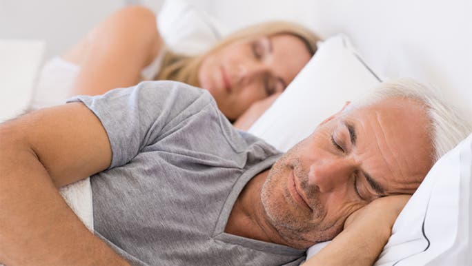 A middle-aged man and woman are sleeping peacefully