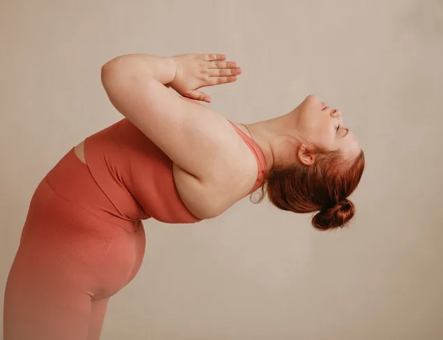 Woman in salmon-pink active wear doing a yoga pose