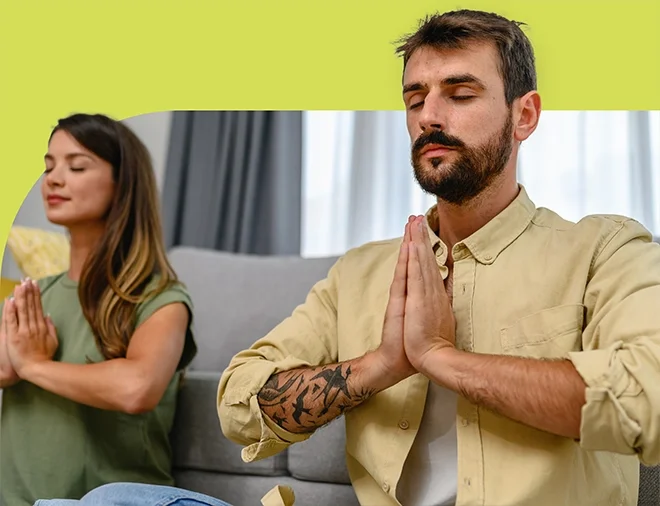 couple sitting together meditating with hands together