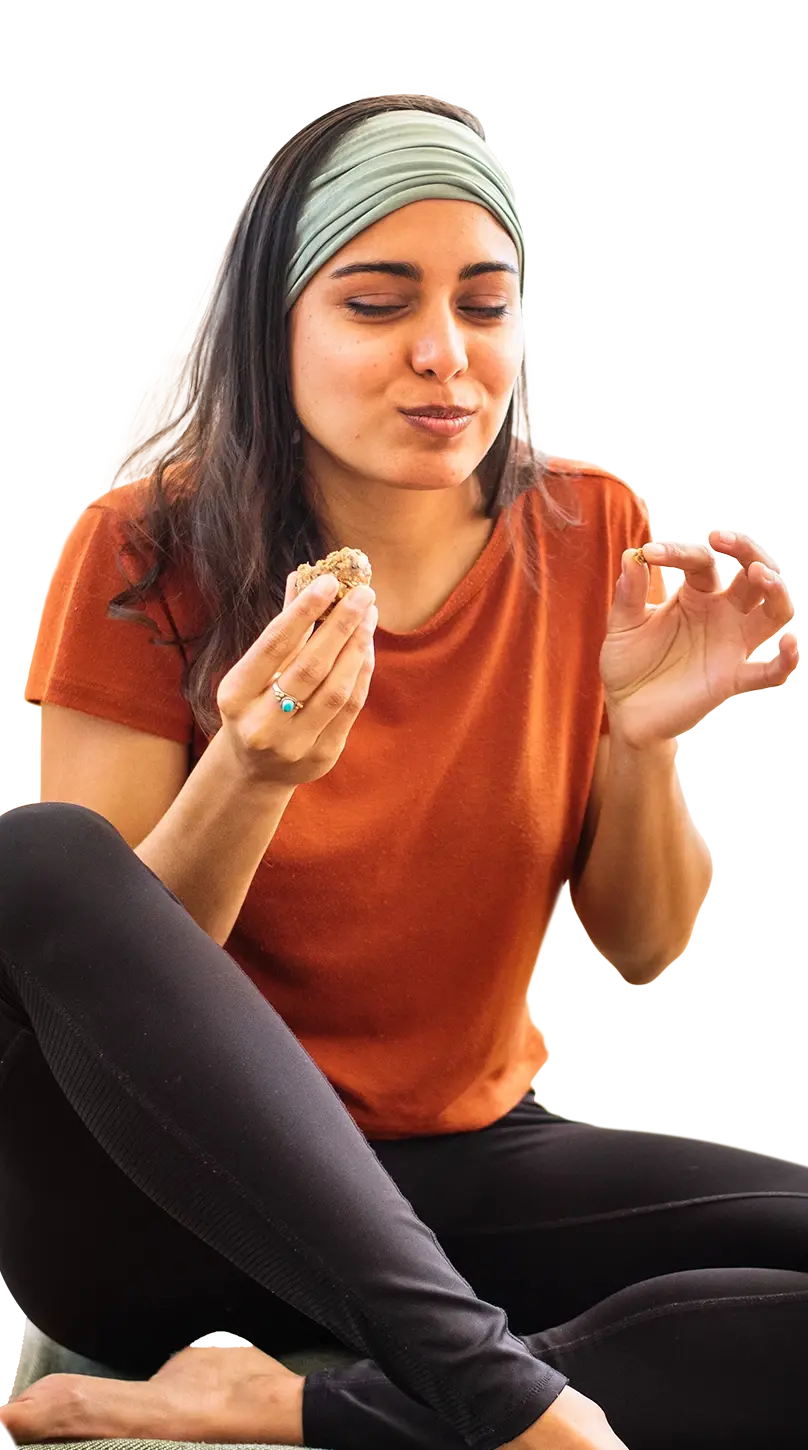Full shot of a woman sitting down enjoying eating a healthy snack.