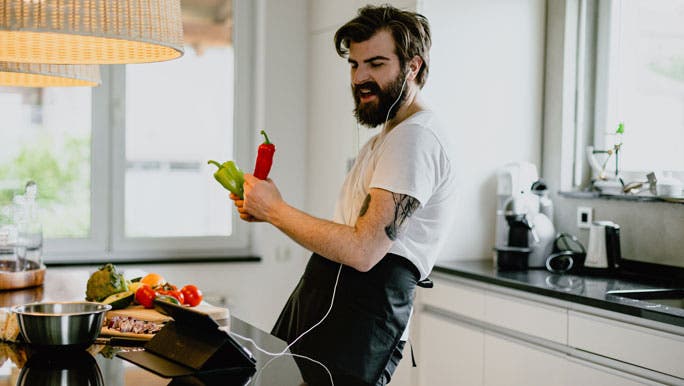 Young man cooking with vegetables