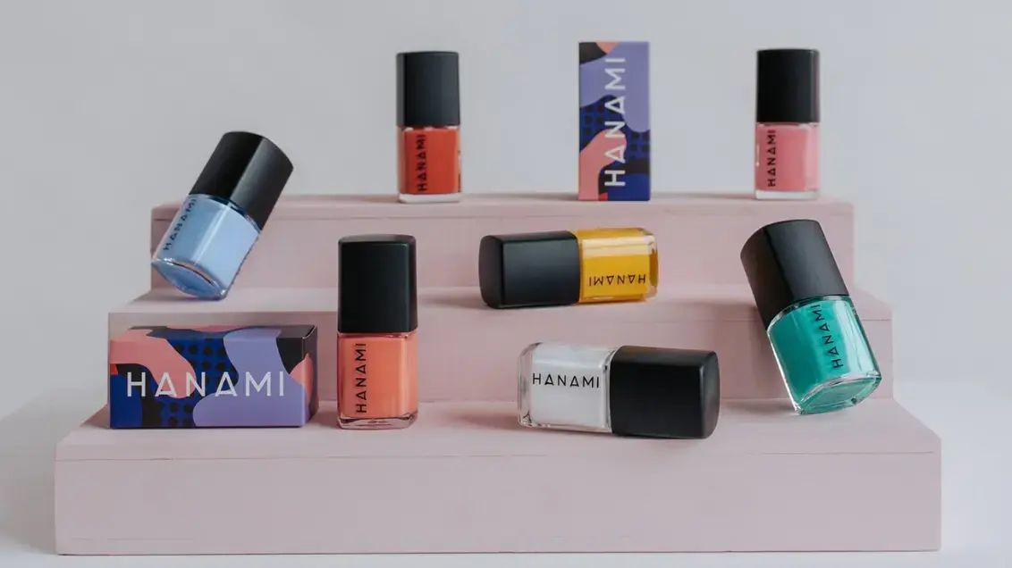 Hanami nail polish bottles and Hanami packaging is arranged in different orientations on cardboard steps.