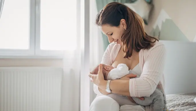 New mum breastfeeding her baby in the nursery
