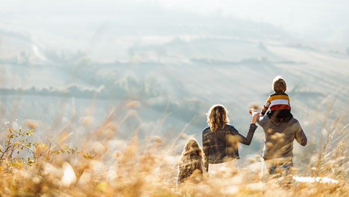 A family is spending time together in nature. They are raising resilient kids by spending quality time together.