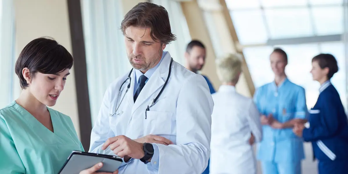 group of physicians collaborating in a hospital hallway