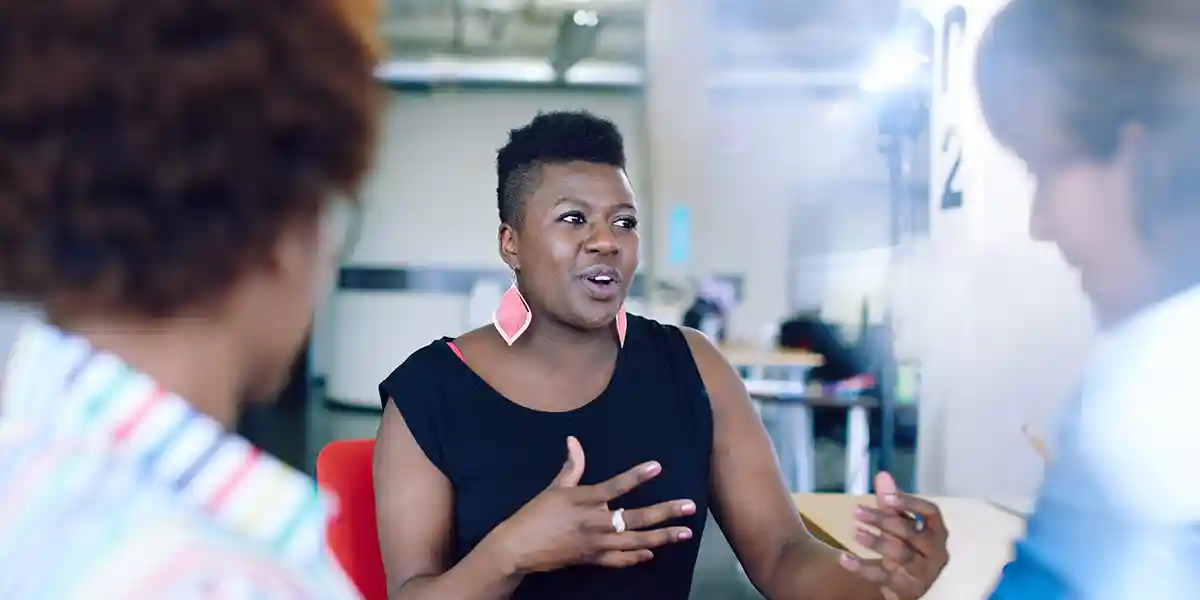 woman confidently discussing leadership development with coworkers