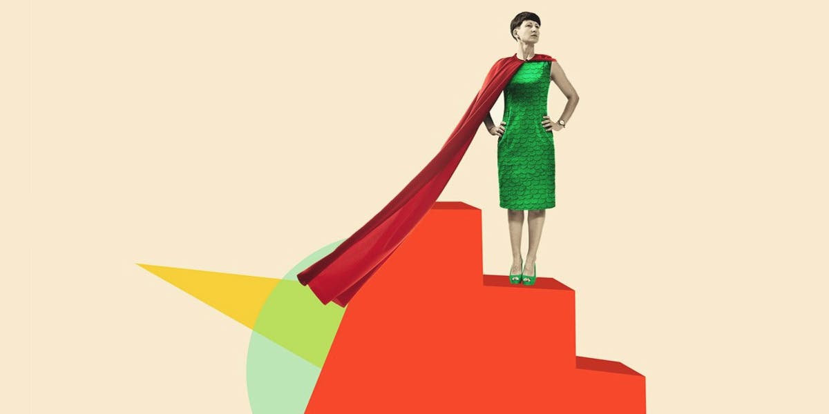 a woman wearing a green dress and red cape, standing on a tiered platform