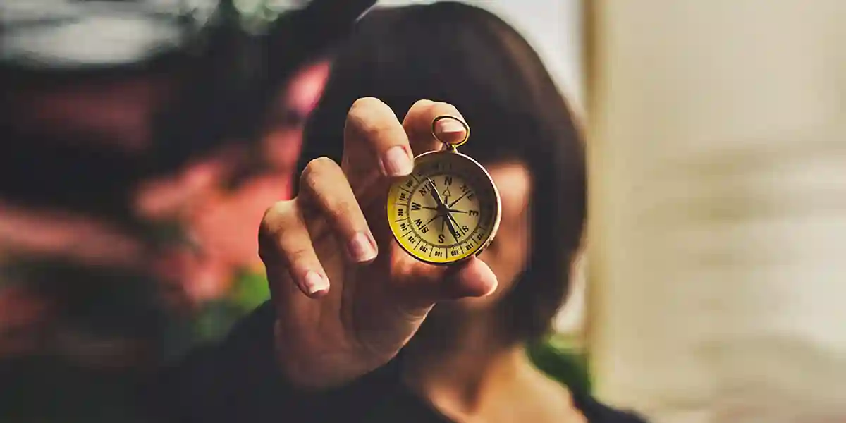 woman holding a compass in front of her face to guide ethical employee hiring process