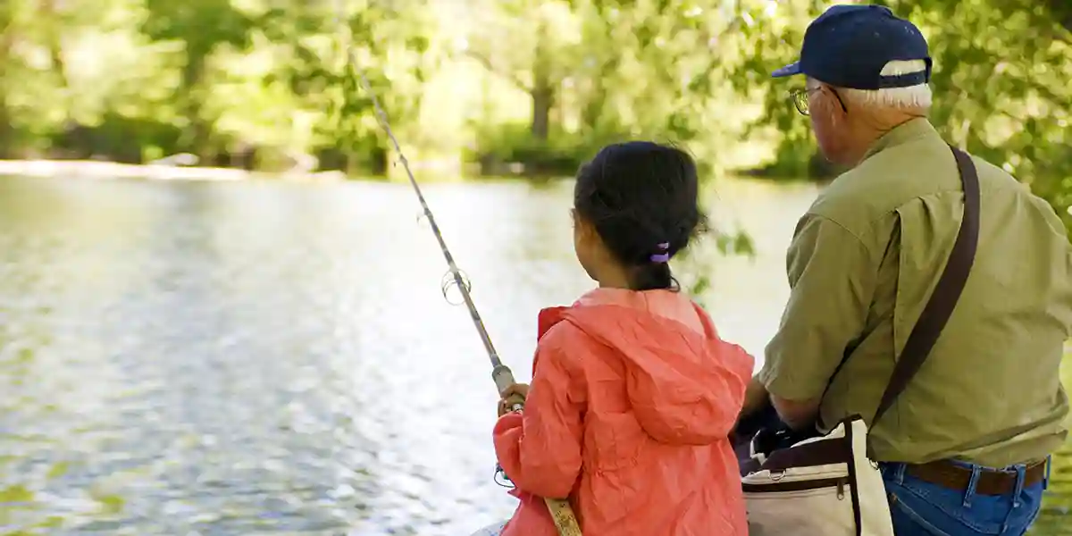 grandfather teaching granddaughter to fish, taking ownership of learning