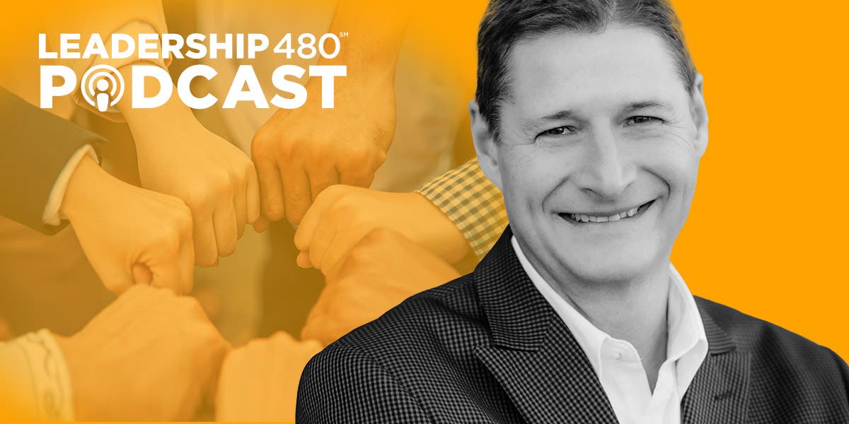 headshot of Dr. Nate Regier with several business professionals' fists huddled in a circle in the background to show that this podcast episode is about how to hold people accountable with compassion