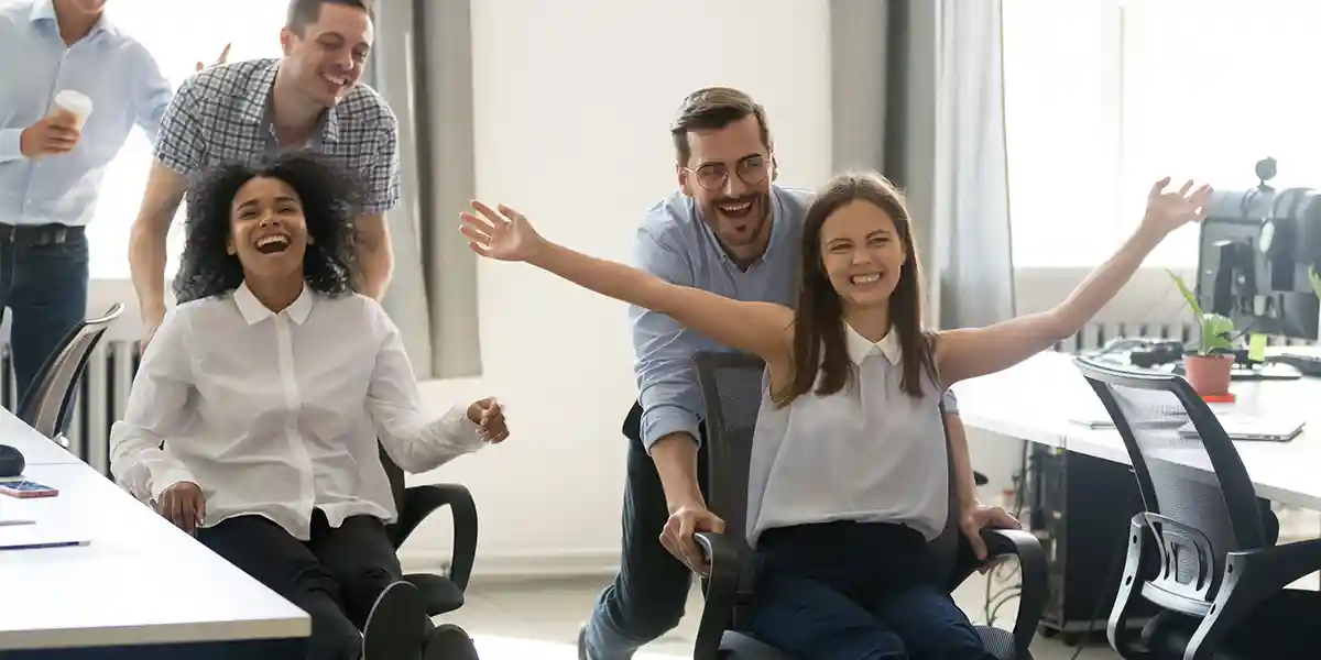 Office chair race, showing this as one method for how to improve employee engagement 