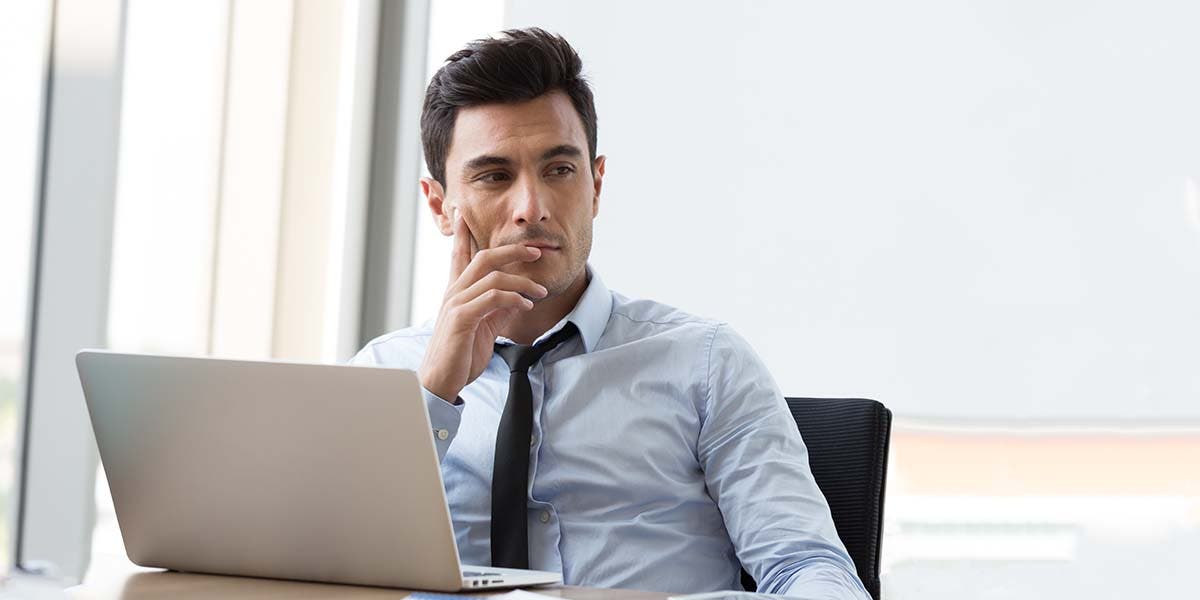man in front of laptop thinking about emerging leader program