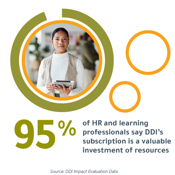 person stands holding a tablet in an office. Graphics around the photo read, "95% of HR and learning professionals say DDI's subscription is a valuable investment of resources" according to DDI Impact Evaluation Data?fm=webp&q=65