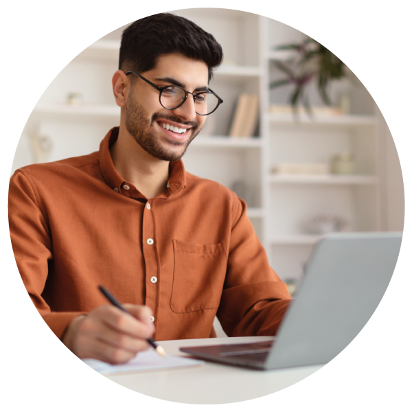 Man Indian leader smiling as he is working on his laptop?auto=format&q=75