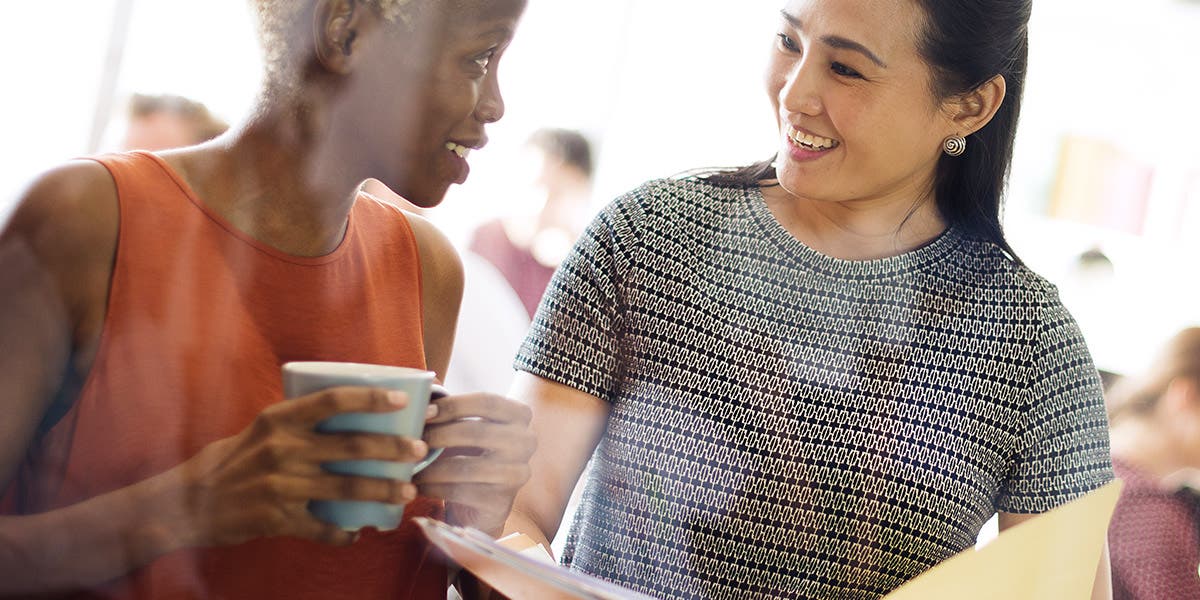 Two women talk while networking, which is key to diversity and inclusion for women.