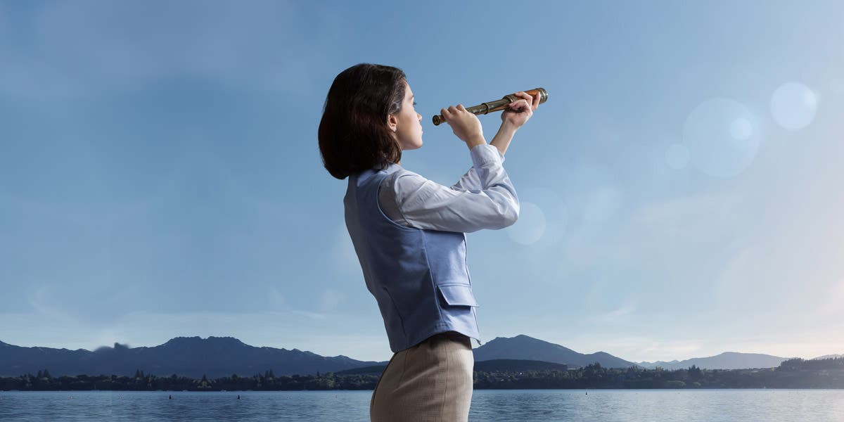 Woman looking through telescope toward the future of leadership development