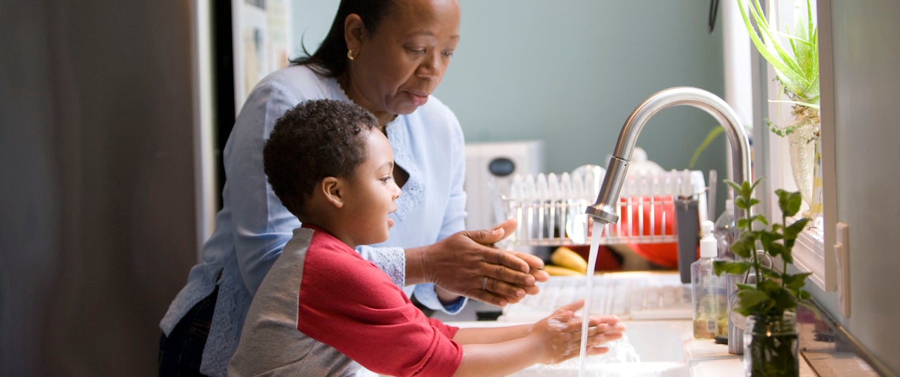 Mum showing son how to wash his hands