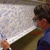 A man reading signatures on the beam