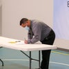 Man signing a document on a table